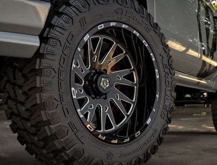 Close-up of a rugged off-road tire with an intricate black alloy wheel on a vehicle.