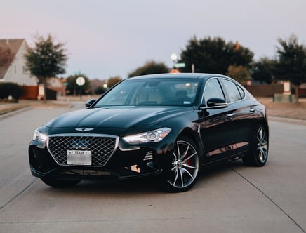 Black Genesis sedan parked on a residential street.