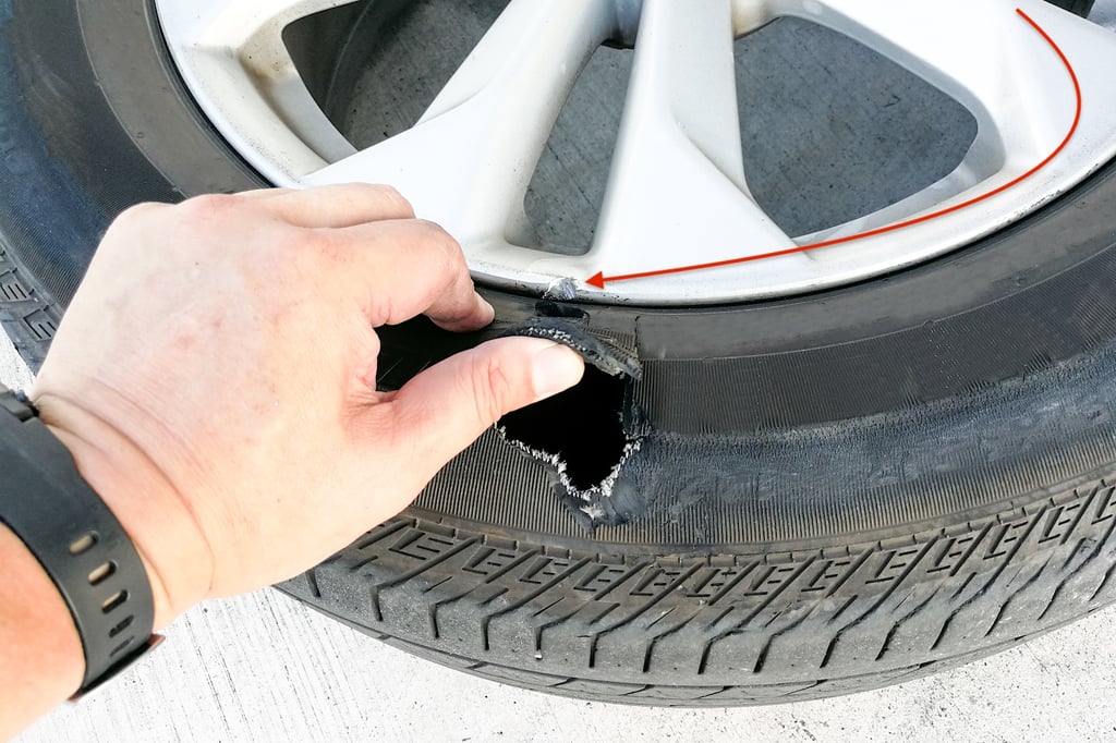 Closeup of a chipped rim and a tire blow out