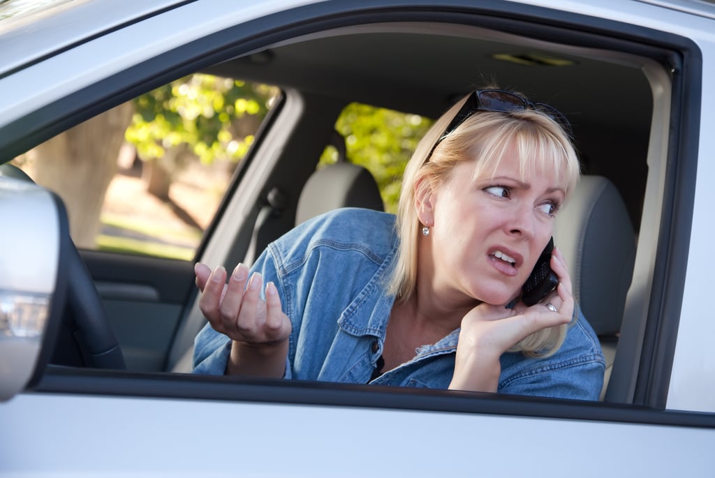 A woman on the phone looks out the window after hearing a weird tire noise.