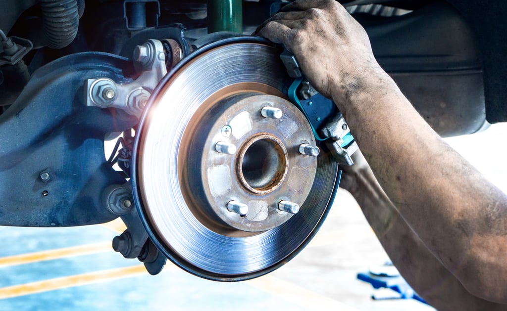 A mechanic installs new brake rotors on a vehicle