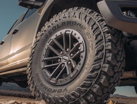 Close-up of a rugged Yokohama Geolandar M/T G003 tire on an off-road vehicle.