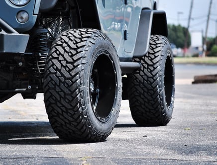 Close-up of large off-road tires on a vehicle.