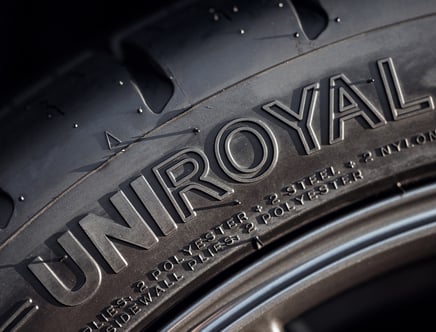 Close-up of a Uniroyal tire showing the brand name and material composition on the sidewall.